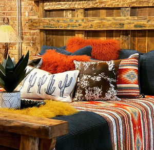 Add a touch of country charm to your homes interior with this lumbar Cactus Cushion.   Sourced by us from Dallas Texas, this Pillow pays homage to the old west with an updated twist. With a background of simple linen with blue cactus that’s really pops. This look is finished with a faux suede piping in a deep rustic copper.  