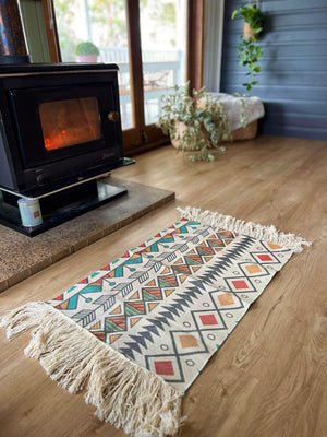 Bring a touch of the Southwest to your living space  These beautiful cotton canvas rugs are the perfect thing to spice up your dining table, sideboards, floors, doorway, anywhere and everywhere. Can be hung as wall art.  Southwest design with grey/blue background. Each rug is handwoven by artisans, stencil printed on cotton canvas with fringe ends.  Size 31.5” - 60x90cm + fringe.  Limited edition. Just a couple of these were made, we think this makes these extra special. 