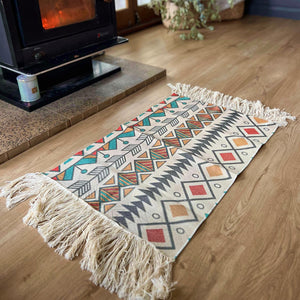 Bring a touch of the Southwest to your living space  These beautiful cotton canvas rugs are the perfect thing to spice up your dining table, sideboards, floors, doorway, anywhere and everywhere. Can be hung as wall art.  Colourful Southwest design in neutral background. Each rug is handwoven by artisans, stencil printed on cotton canvas with fringe ends.  Size 31.5” - 60x90cm + long fringe.