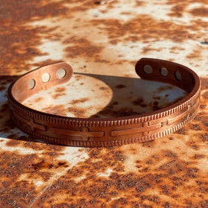 Slimmer than the cowboys cuff, however still a nicely weighted solid copper. Patina copper finish.  All our copper cuffs are handmade and generous in fit. (adjustable American sizing)  This cuff fits in between, so it’s perfect for either Cowboys or Cowgirls. (Men’s M/L - Ladies L/XL).