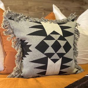 As seen styled in Western Magazines.  These versatile cushions can be used to spice up a room, add glamour, colour and texture or simply provide the finishing touch to any space.  This throw cushion features Navajo-inspired geometric motif and fringed edge. Modern colours of silver-grey, black and white accent.