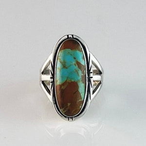 Get your hands on this stunning Vintage Ring. It’s has an exquisite Turquoise stone, you won’t want to take your eyes of it.   Made by Navajo artist Alfred Joe, this ring is set in Sterling silver with stunning Pilot Mountain Boulder turquoise. The oval cut stone is set in a smooth sterling bezel and accented with a cut and notched edge. Stamped. Size of Setting: 1” by 1/2 ”