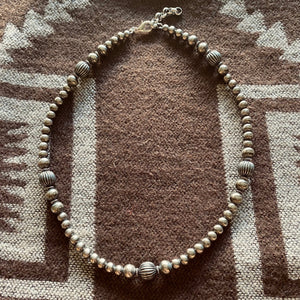 This Western design is the long strand of 5, 6 and 8mm Navajo Pearls with 'Southwest’ pumpkin beads.   Stunning long 16” for that desirable Western style. The clasp comes with a 1" extension chain so you can play with the length.  These Navajo Pearls are handmade by our artisan in CO USA, each bead is plated in sterling silver, antiqued & polished. Midi priced pearls, more affordable that our pure silver and vintage pieces. 