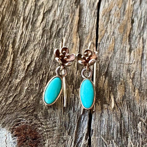 Petite Pretties  Rare AAA Grade 100% natural Sleeping Beauty Turquoise earrings in .925 sterling silver.  These stunning sleeping Beauty turquoise stones are hand set by artisan in sterling silver with gold patina! The natural Sleeping Beauty stones measure 6x10mm.   Earrings petite cast floral earwire is 1.2" in length!