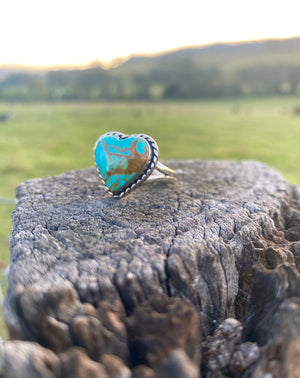 Get your hands on this stunning Navajo Ring. It’s has an exquisite Turquoise stone, you won’t want to take your eyes of it.   This adorable heart ring was made by Navajo artist Alfred Joe and is set with # 8 turquoise. The heart cut stone is set in a smooth sterling bezel and accented with sterling twist rope. Stamped.  Size of Setting: 3/4” by 3/4 ”Heirloom item.  One of a kind collectors item to be worn, admired and treasured.   Size AUS P-Q. 8 3/4 (Medium-Large) see our ring guide. 