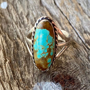 Get your hands on this stunning Navajo Ring. It’s has an exquisite Turquoise stone, you won’t want to take your eyes of it.   Made by Navajo artist Alfred Joe, this ring is set with boulder turquoise. The oval cut stone is set in a smooth sterling bezel and accented with sterling twist rope. Size of Setting: 1” by 1/2 ”  Heirloom item. One of a kind collectors item to be worn, admired and treasured.