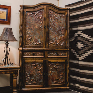 <p><span>Western luxury at its best, </span><span>this real wood Armoire will be the centre piece in your Ranch or modern-country home.</span></p> <p>Handcrafted in solid Mexican reclaimed wood with a smoky-amber finish this majestic Armoire features hand tooled verdigris copper panels, Western-style carved wood accents and forged-iron hardware. Crafted by Mexican Artisans, the copper is skilfully hammered by hand then treated to create this stunning finish.</p>