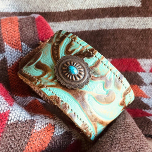 Vintage Western  Embossed leather cuff with Southwest Concho   Handmade. Two layers of leather have been expertly stitched together. The inside leather is soft on your wrist.  The fit: cuffs are approx 8 1/2 inches end to end with button and eye closure. There are two slots for different fits. 