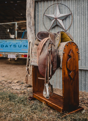 Display your Pride and Joy on this custom saddle stand. Made here at Swan Creek in 🇦🇺 Solid Pine   Photos (high finish) Smokey walnut stain with satin-poly finish. Top mount or full front Clavos - genuine Mexican nailhead accent. Comes with under rail hook.  Size 740mm High x 740mm Long x 320mm Wide  We make these to custom order - usually within the same week. (Christmas orders and events times may vary)