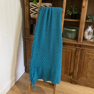 Woven textile to add that touch of rich teal hue to your room.  Contemporary design with elegant Diamond texture and plush fringe ends  Perfect for draping over the back of the couch or across your bed. This lovely longer throw features; traditional pattern and fringed ends. 