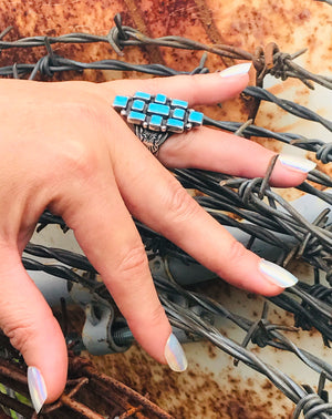 Queen of the Southwest  The Stones: Gorgeous bright blue Sleeping Beauty turquoise setting with 11 genuine carved Sleeping Beauty stones measuring 5x7 to 9x7mm in sterling silver.  The band: Handmade by silver-maker in .925 Sterling Silver this custom wide band has vintage Southwest / Navajo detail. Made in size 9 / R this exquisite ring will fit the wider fingers. Statement size 35x23mm. New Mexico Artisan. Stamped.