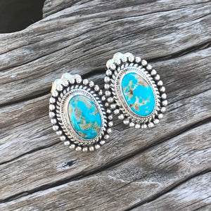 The Stones. Gorgeous 100% natural turquoise in azure blue with golden tan matrix from the Sierra Nevadas.   Bright blue 100% natural turquoise cabochon size 18x15mm each.  Stamped .925 sterling silver, artisan crafted in New Mexico. This incredible pair of earrings measure .75" in length including the sterling silver etched setting. Post studs with artisan backs.