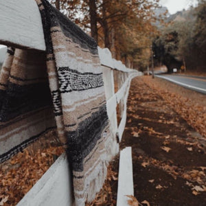 These versatile Southwest blankets are perfect to spice up your living space.  Lay it over the bed or patio furniture, use as an accent floor rug, wall tapestry or take it on your weekend adventure.    Made in Mexico; hand-loomed falsa blanket with fringe ends. Measures: 73"X48" (Inches) Fabric: Recycled Cotton, Acrylic and Polyester blend. 