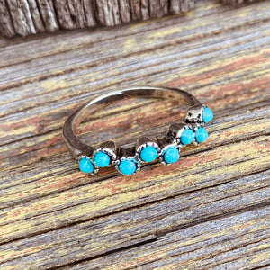 Lovely ring with 8 bright turquoise-blue gems.  Artisan made in .925 Sterling silver.   The gems are made from reconstructed Turquoise, not the same quality as our more expensive quality rings, however beautiful in its own right.  Comfortable to wear every day.