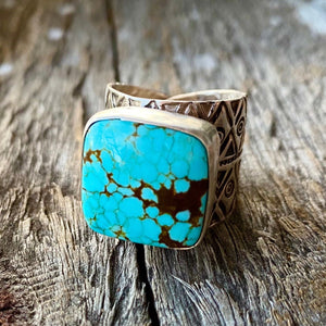 Collectors Turquoise. One of a kind. Exquisite.  Vintage No #8 Turquoise cabochon mined in Nevada in the 1980`s. The stone is cushion set with uniquely detailed sterling silver band. Large 17.5mm stone with exquisite sky blue colour and matrix spider webbing.  Adjustable Cigar band ring from size 7 to 10. Ring width tapers from 19.5mm at the center to 8.9mm at the back. Very comfortable to wear. Fit medium to large fingers.