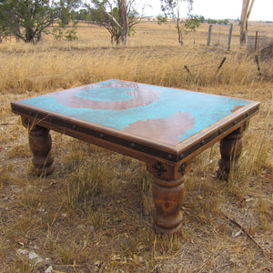 Western luxury in your Ranch or country home  Handcrafted in solid exotic Brazilian Pine wood with a smoky-amber finish this large coffee table features a striking patina blue copper top, Western-style turned legs, nail-head accent and forged-iron hardware. Crafted by Mexican Artisans, the copper is treated by hand to create this stunning patina finish.  H51 x D/W93 x L120 (CM). This coffee table is part of the Brazos Collection.